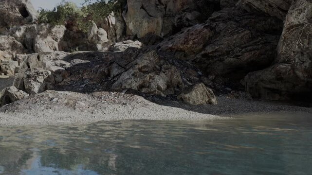 The scene shows a rocky shoreline with clear water. The sun casts shadows on the rocks and highlights the details of the shoreline. Nearby vegetation adds to the natural setting.