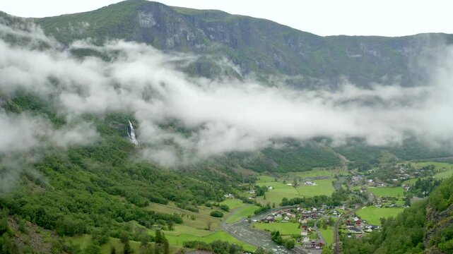 Stunning aerial view of Fl&aring;m valley and waterfall landscape in Norway with rolling clouds.