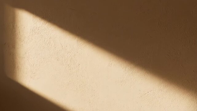 Warm sunlight beam shining diagonally across textured brown plaster wall surface