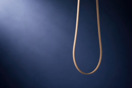 Hanging rope noose on dark blue background with dramatic empty space