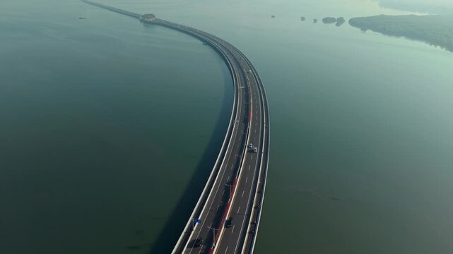 Aerial view of the Bali Mandara Toll Road stretching over the calm sea in Kecamatan Kuta Selatan, Bali, Indonesia.