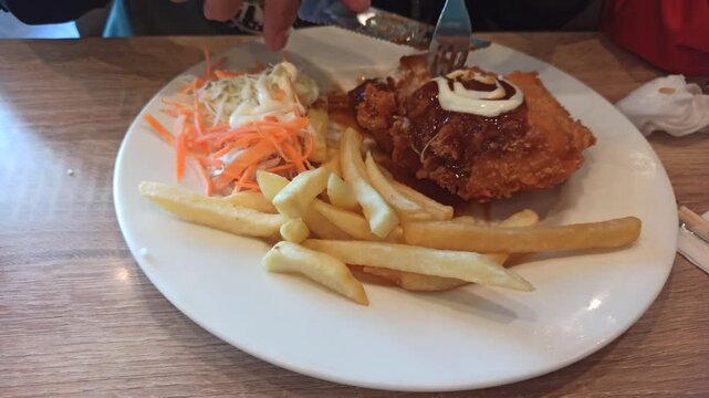 A delicious serving of chicken cordon bleu accompanied by crispy French fries, offering a classic combination of tender chicken, melted cheese, savory filling, and golden fried potatoes in an appetizi