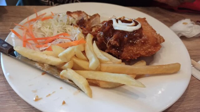 A delicious serving of chicken cordon bleu accompanied by crispy French fries, offering a classic combination of tender chicken, melted cheese, savory filling, and golden fried potatoes in an appetizi