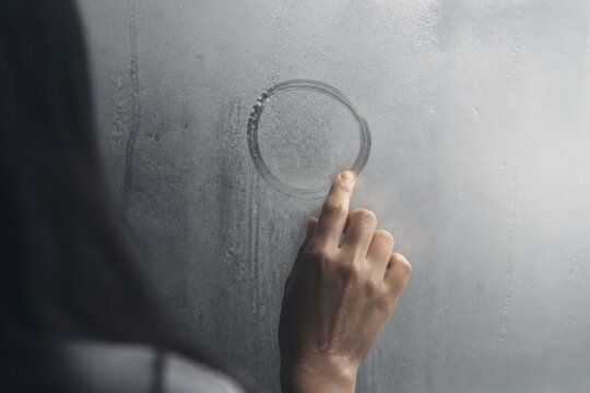 Condensation on fogged glass with finger tracing a circle
