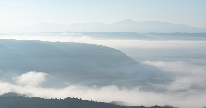 早朝の阿蘇北外輪山の山並みと谷間を流れる雲