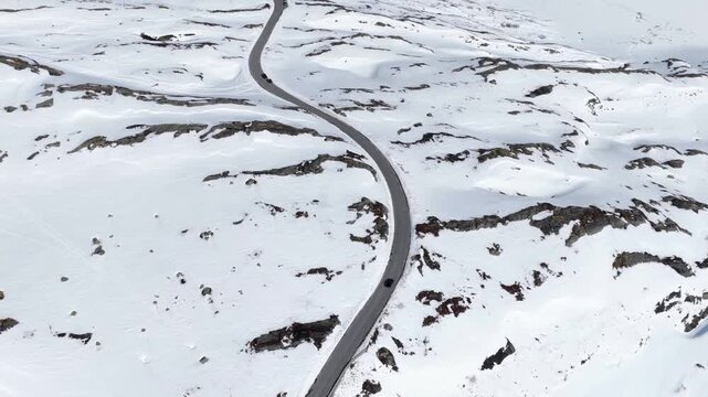 Aerial view of the winding Trollstigen mountain road surrounded by snow-covered peaks in Andalsnes, More og Romsdal, Norway.