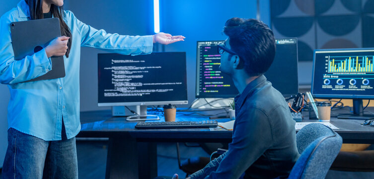 Asian happy woman and man programmer team coding software at computer in dark tech office, Concept of digital transformation, modern cyber security, startup teamwork and future IT digital network