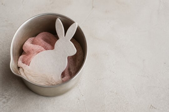 Rabbit cutout in metal bucket on pastel background