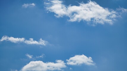 Obraz premium Bright Blue Sky with Fluffy White Clouds on a Sunny Day Background with Central Copy Space