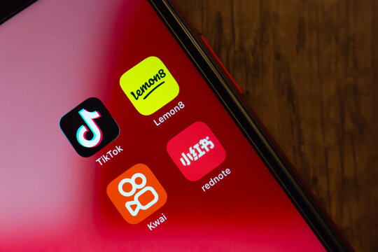 Mexico City, MEXICO - Jul 21 2026 : Close-up of an iPhone home screen showing TikTok, Lemon8, rednote and Kwai app icons on a red gradient wallpaper.