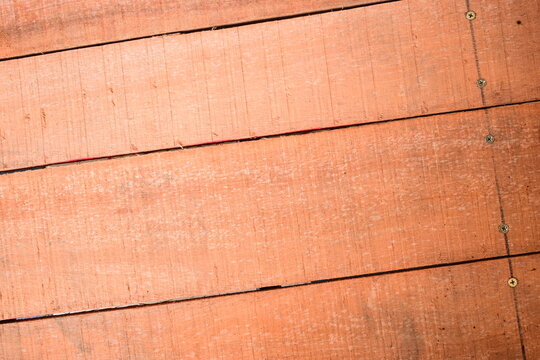natural reddish brown wooden board texture background with visible screw
