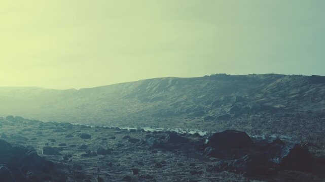 A landscape shows rocky mountains and a small stream flowing through the valley. The sky is light and cloudy. The area appears isolated and vast.