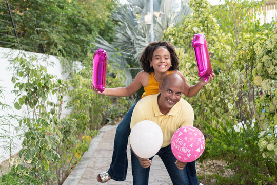 Father giving daughter piggyback ride celebrating birthday