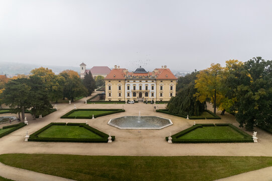 Aerial view of the baroque Slavkov Castle with its manicured gardens, octagonal fountain, and autumn trees in Slavkov u Brna, South Moravian Region, Czechia.