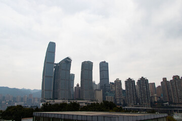 Naklejka premium Landscapes large building skyscraper structure in business district in big city at Chongqing City, China. Architecture of construction city rapid, large. Top with sky with white clouds is background. 