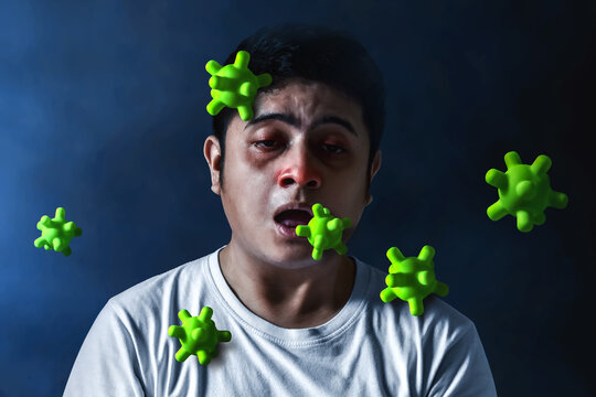 Sick young man and green virus cells on dark background