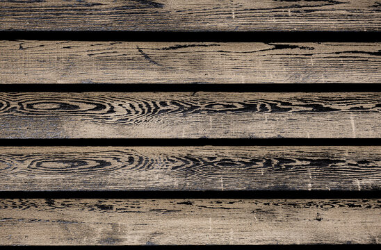 Weathered horizontal brown wood slats background texture with high contrast black grain patterns.