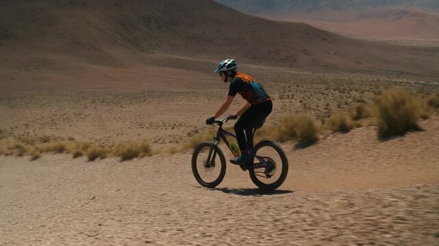 Mountain biker descending a northern chile landscape sandy hill