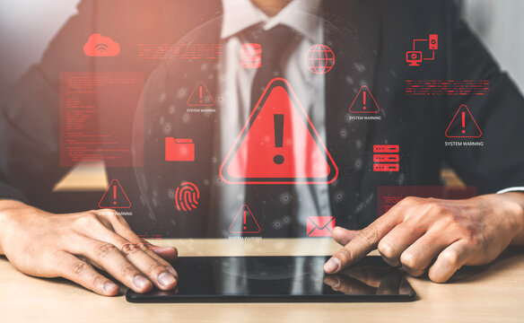 A businessman uses a tablet surrounded by digital warning symbols, reflecting the pressing issues of cybersecurity threats and the need for vigilance in the modern workplace. Cyphers