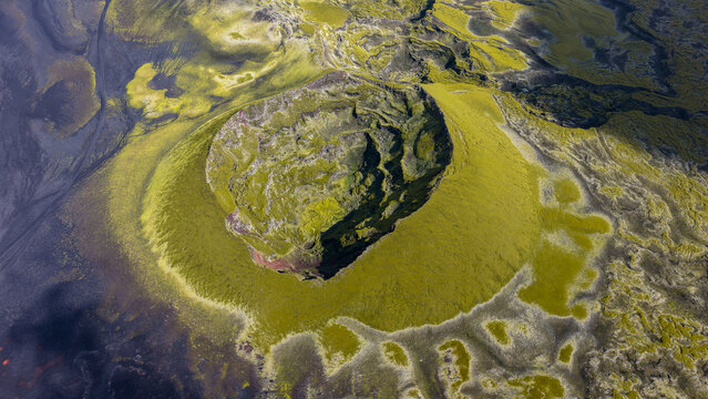 Aerial view of the Laki volcanic crater, featuring vibrant green moss-covered lava fields and dark volcanic rock formations in the highlands of Kirkjubaejarklaustur, Skaftarhreppur, Iceland.