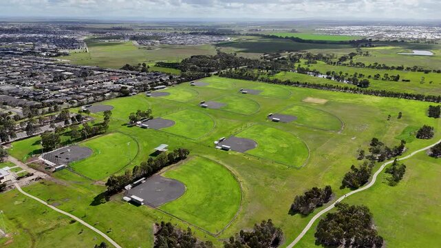 Aerial high-angle view of a large multi-field baseball and softball facility adjacent to modern residential suburban neighborhood in a new estate in Wyndham Vale, Melbourne, Australia.