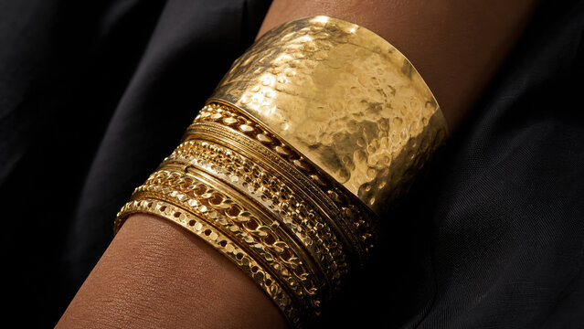 Gold cuff bangles on wrist