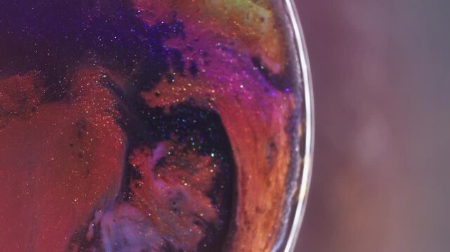 Shimmer paint splash. Multicolor flow. Defocused orange blue purple rainbow glitter particles spreading on abstract vibrant creative background.