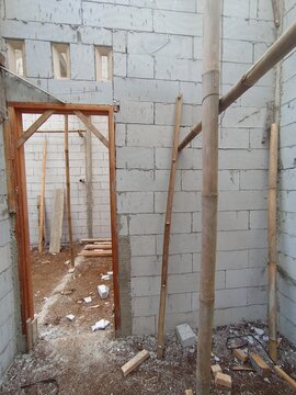 Unfinished house interior with lightweight concrete block walls and bamboo scaffolding at site