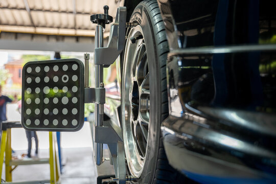 Closeup of car wheel alignment at auto repair center. Vehicle maintenance service in an automotive workshop