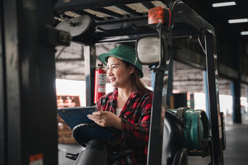 Naklejka premium Adult female engineer depicted Asian woman confidently operates forklift truck at factory showcasing expertise in industrial occupation effectively managing tasks within industrial warehouse setting.