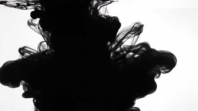 Black ink swirling in water creating abstract fluid shapes and patterns on a white background
