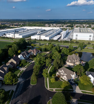 Hilliard, Ohio, United States - 21 August 2026: Aerial view of the Amazon data center located adjacent to a suburban residential neighborhood with lush green trees and clear blue sky.