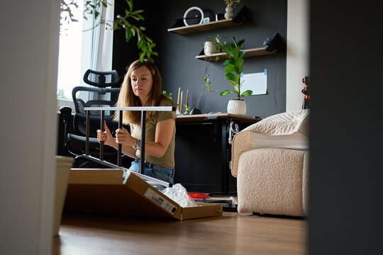 Independent woman building a metal shelving unit for her home office