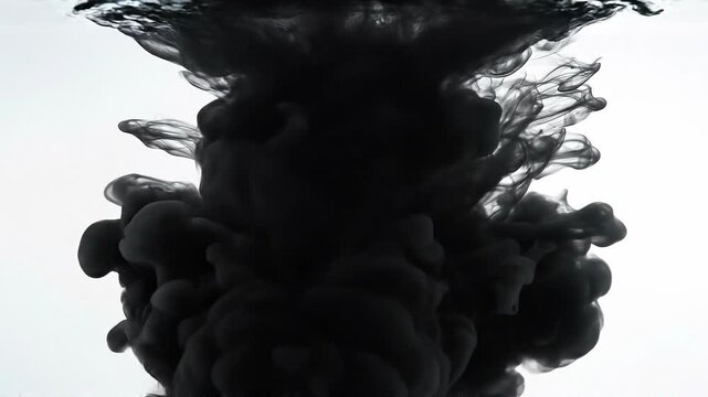 Black ink swirling in clear water with abstract fluid shapes and smoke like patterns
