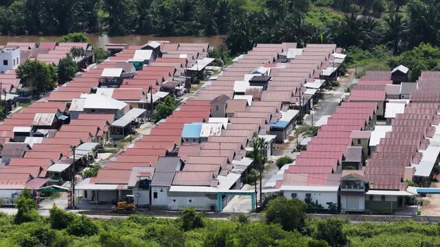 Rows of colorful residential houses seen from above surrounded by lush green trees and nature