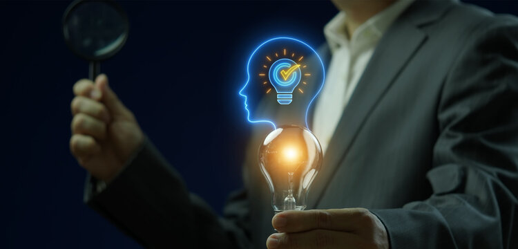 Close-up vertical shot of hand holding magnifying glass to inspect glowing lightbulb in human head profile thinking idea. Cognitive thought process analysis, intellect innovation, and wisdom concept.