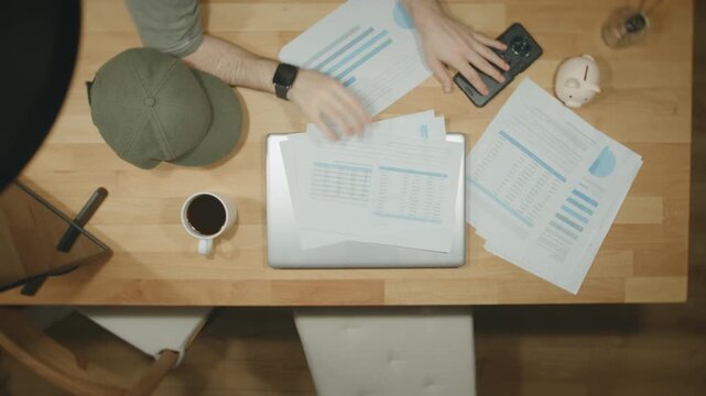 Man Reviewing Financial Reports Charts Documents Desk Business Analysis Overhead View