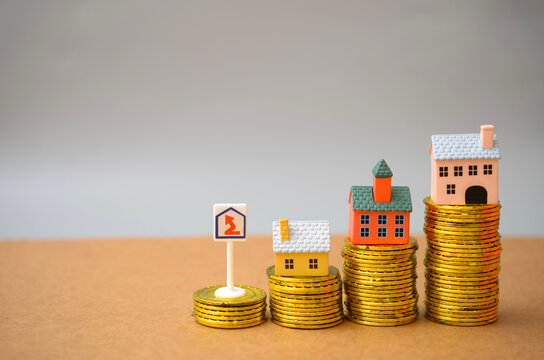 Rising Property Prices and Real Estate Investment with Houses on Coin Stacks