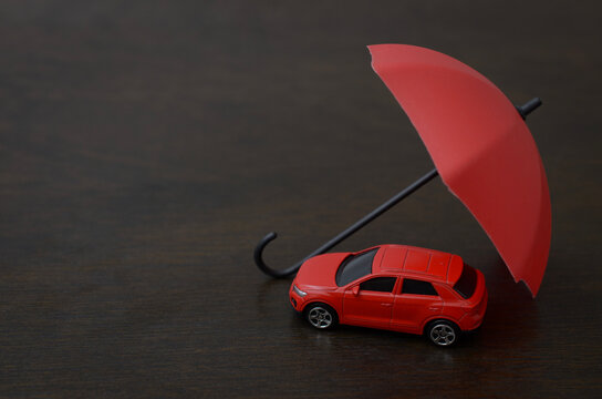 Car Insurance Protection Concept with Vehicle Sheltered Under Umbrella