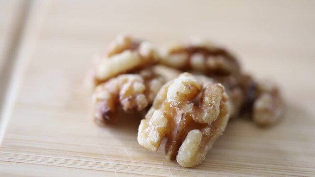 Close-up of shelled walnut kernels on a wooden cutting board in natural light