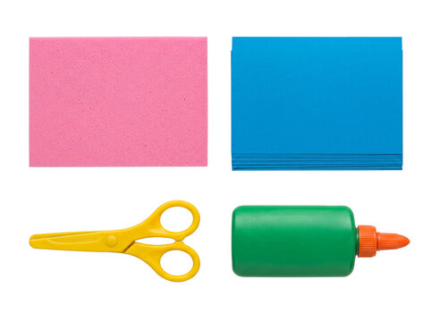 Vibrant crafting essentials collection: pink foam board, blue paper stack, yellow scissors, and green glue.