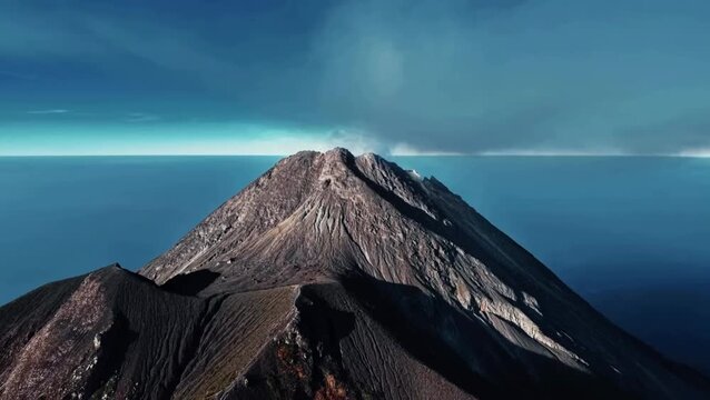 Aerial View of Smoking Mount Merapi Volcano Crater and Ridge Above Sea of Clouds