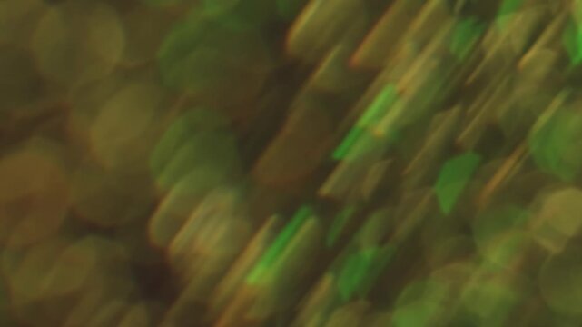 Sparkling glare art. Blurred gleam. Duplicated lens flare prism stroboscopic color rotation. Shiny bokeh light leak green yellow abstract background.