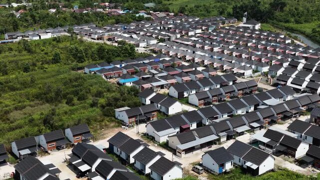 Rows of small family houses built in a rural landscape near green forest in South Kalimantan