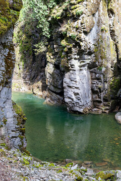 Clear emerald water flowing through the steep granite rock cliffs of Coquihalla Canyon at Othello Tunnels in Hope, British Columbia.