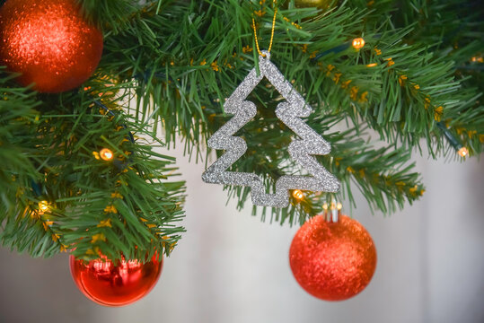 Close-up view of Christmas gifts under a decorated tree with red wrapping in a cozy home interior.