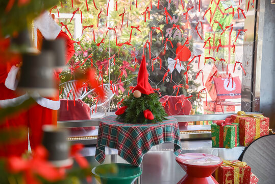 Close-up view of Christmas gifts under a decorated tree with red wrapping in a cozy home interior.
