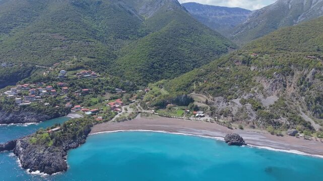 Panoramic drone orbit capturing the lush green landscape of Evia, the deep blue Aegean Sea, and the scenic Limnionas Beach along the rugged Mediterranean coastline.