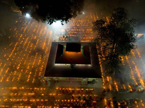 Aerial view of Hindu devotees participating in Rakher Upobash at Loknath Temple in Barodi, with thousands of glowing oil lamps illuminating the night in Narayanganj, Dhaka, Bangladesh.
