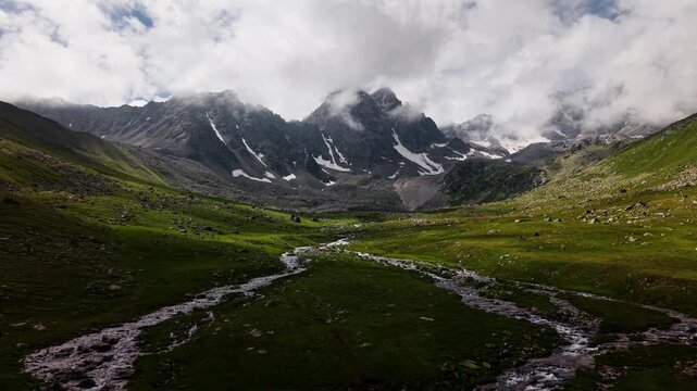 Aerial Forward Movement Over Alpine Valley and Mountain Stream